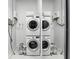 A modern laundry room features stacked white washer and dryer units, plus storage and a tankless water heater at 150 E Robinson St # 407, Orlando, FL 32801