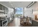 Open-concept living area features modern kitchen, spiral staircase, and a wall of windows offering stunning views at 150 E Robinson St # 407, Orlando, FL 32801