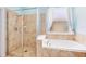 Bathroom featuring a glass-enclosed shower, soaking tub, and travertine tile at 1617 Song Sparrow Ct, Sanford, FL 32773
