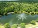 An aerial view of a pond with a fountain surrounded by lush greenery at 1617 Song Sparrow Ct, Sanford, FL 32773