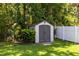Backyard shed features gray double doors and is surrounded by green grass and lush plants at 1617 Song Sparrow Ct, Sanford, FL 32773