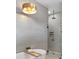 Modern bathroom featuring a soaking tub, a sleek glass-enclosed shower and a unique wood and metal light fixture at 1780 Mizell Ave., Winter Park, FL 32789
