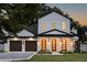 Striking two-story home with a three-car garage and a covered porch entrance, illuminated for evening viewing at 1780 Mizell Ave., Winter Park, FL 32789
