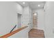 Upstairs hallway with wood floors and neutral walls, leading to a bathroom with shower and toilet at 1780 Mizell Ave., Winter Park, FL 32789