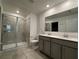 Bathroom showcasing double vanity, tiled floors, and glass-enclosed shower at 1950 Birnham Wood Bnd, Kissimmee, FL 34746