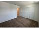 Simple bedroom with plush carpeting, closet space, and a door leading to a tile-floored area at 1950 Birnham Wood Bnd, Kissimmee, FL 34746