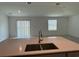 Modern kitchen sink with a stainless steel faucet and double basin, overlooking the living area at 1950 Birnham Wood Bnd, Kissimmee, FL 34746