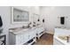 Bright bathroom featuring dual vanities with marble countertops, wood-look floors, and a separate soaking tub at 19606 Reynolds Pkwy, Orlando, FL 32833