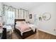 Stylish bedroom with a wood bed frame, vine decor, wood-look floors, and a pink throw at 19606 Reynolds Pkwy, Orlando, FL 32833