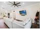 Spacious living room with a large sectional sofa, a ceiling fan, and a mounted TV at 19606 Reynolds Pkwy, Orlando, FL 32833