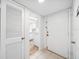 Entryway view showing a doorway leading to a bright kitchen with white appliances and a tiled floor at 200 St Andrews Blvd # 601, Winter Park, FL 32792