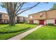 Attractive two-story condo building with lush lawn, mature trees and red front doors and shutters at 200 St Andrews Blvd # 601, Winter Park, FL 32792