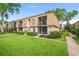 Exterior of a well-maintained condo building with lush landscaping and mature trees at 200 St Andrews Blvd # 601, Winter Park, FL 32792