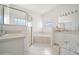 Bright bathroom features a glass enclosed shower, soaking tub, and double sink vanity at 20130 Sunset Landing Ave, Groveland, FL 34736