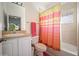 Small bathroom features a vanity, toilet, and shower/tub with colorful curtain at 20130 Sunset Landing Ave, Groveland, FL 34736