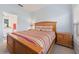 Comfortable bedroom featuring a wood frame bed, side table, and large window at 20130 Sunset Landing Ave, Groveland, FL 34736