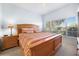 Comfortable bedroom featuring a wood frame bed, side table, and a large window at 20130 Sunset Landing Ave, Groveland, FL 34736