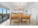 Dining area with wooden table and chairs, complemented by a modern chandelier and sliding glass doors at 20130 Sunset Landing Ave, Groveland, FL 34736