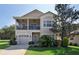 Two-story home showcasing a balcony, manicured lawn, and attached one-car garage at 20130 Sunset Landing Ave, Groveland, FL 34736