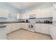Well-lit kitchen featuring white cabinets, tiled floors, and modern appliances at 20130 Sunset Landing Ave, Groveland, FL 34736