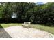 Brick patio with wrought iron bench in a lush, landscaped backyard at 203 Brookgreen Way, Deland, FL 32724