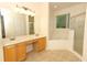 Bathroom featuring double vanity, bathtub and glass-door shower at 203 Brookgreen Way, Deland, FL 32724