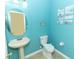 Charming half bathroom featuring a pedestal sink, toilet, and nautical-themed decor at 203 Brookgreen Way, Deland, FL 32724