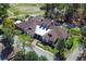 An aerial view showcases a grand clubhouse with a bright roof, embraced by lush greenery and scenic surroundings at 203 Brookgreen Way, Deland, FL 32724