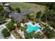 Aerial view of a uniquely shaped community pool with palm trees, lounge chairs, and landscaped surroundings at 203 Brookgreen Way, Deland, FL 32724