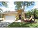 Charming one-story home featuring a stucco exterior, a stone column, and a well-manicured front lawn at 203 Brookgreen Way, Deland, FL 32724