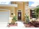 Close-up of the front entrance showcasing a decorative glass door, stone accents, and manicured landscaping at 203 Brookgreen Way, Deland, FL 32724
