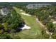A scenic aerial shot presenting a well-manicured golf course, dotted with sand traps, and enveloped by lush trees at 203 Brookgreen Way, Deland, FL 32724
