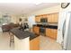 Modern kitchen with stainless steel appliances, light wood cabinets, a breakfast bar, and open access to the living room at 203 Brookgreen Way, Deland, FL 32724