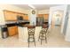 Bright kitchen featuring wood cabinetry, black countertops, and a breakfast bar with seating for two at 203 Brookgreen Way, Deland, FL 32724
