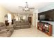 Relaxing living room with a large TV, comfortable sofa, and open layout to the kitchen at 203 Brookgreen Way, Deland, FL 32724