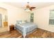 Inviting main bedroom with wood floors, ceiling fan, and a large window for natural light at 203 Brookgreen Way, Deland, FL 32724
