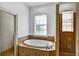 Bathroom featuring a large soaking tub, a tiled shower and neutral tile throughout at 205 Trail Bridge Ct, Winter Garden, FL 34787
