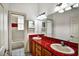 Bright bathroom featuring double sinks with a distinctive red tiled countertop and large mirrors at 205 Trail Bridge Ct, Winter Garden, FL 34787