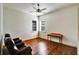 A bedroom with hardwood floors, two windows with blinds, a desk, and two leather chairs at 205 Trail Bridge Ct, Winter Garden, FL 34787