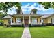 Charming home featuring a well-manicured lawn, covered front porch, and brick walkway leading to the entrance at 205 Trail Bridge Ct, Winter Garden, FL 34787