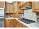 A kitchen area featuring wooden cabinets, stainless steel appliances, tile countertops, and a gas stovetop at 205 Trail Bridge Ct, Winter Garden, FL 34787