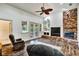 Open living room featuring vaulted ceilings, hardwood floors, brick fireplace, and French doors to the lanai at 205 Trail Bridge Ct, Winter Garden, FL 34787