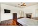 A spacious main bedroom with hardwood floors, a fireplace, and a wall-mounted television at 205 Trail Bridge Ct, Winter Garden, FL 34787