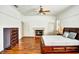 A spacious main bedroom with hardwood floors, a fireplace, and a wooden bed frame at 205 Trail Bridge Ct, Winter Garden, FL 34787