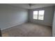 A bright bedroom with neutral carpet, white walls, and a large window overlooking a field at 2355 Seven Oaks Dr, St Cloud, FL 34772