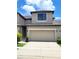 Attractive exterior of the townhome with beige paint, garage, and well-kept landscaping at 2355 Seven Oaks Dr, St Cloud, FL 34772