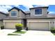 Modern townhome showcasing the attached garages and neutral paint colors on a sunny day at 2355 Seven Oaks Dr, St Cloud, FL 34772