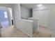 A bright hallway with neutral carpeting, white trim, and ample closet space, connecting various rooms at 2355 Seven Oaks Dr, St Cloud, FL 34772