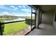 Screened-in patio overlooking the lake with green grass, landscaping, and blue sky at 2355 Seven Oaks Dr, St Cloud, FL 34772