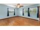 Bedroom with wood floors, ceiling fan, and two windows with views of the backyard at 2538 Meadowview Ln, Deland, FL 32720